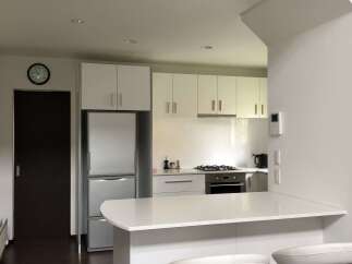 This modern kitchen features sleek white cabinetry and a spacious island with bar seating, perfect for casual dining and entertaining.