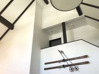 This stunning property boasts a unique vaulted ceiling with exposed dark wood beams, creating a dramatic and spacious feel.