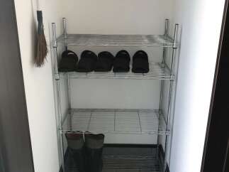 Maximize your entryway storage with this practical wire shelving unit, perfect for organizing shoes and boots.