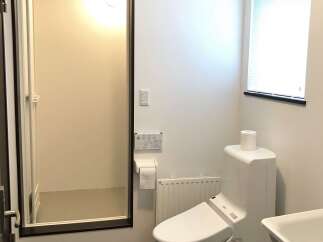 This modern bathroom features a sleek, white toilet with advanced bidet functions and a convenient toilet paper holder.