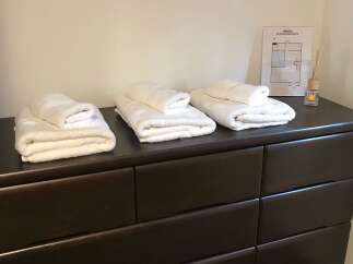 Experience comfort and convenience in this well-appointed room, featuring neatly folded towels ready for your use.