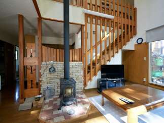 Experience cozy living in this charming home featuring a rustic wood-burning stove as a focal point, perfect for warm gatherings.