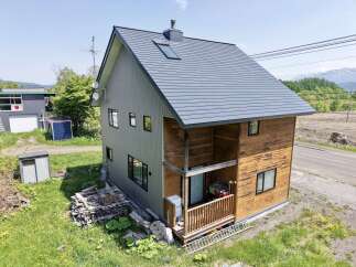 Discover this charming home featuring a unique blend of modern and rustic design, with a sleek gray exterior complemented by warm wooden accents.