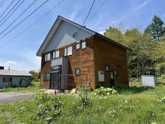 Discover this charming property featuring a modern wooden exterior and a striking corrugated metal roof.