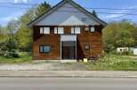 Charming wooden house with a modern entrance, featuring multiple windows for natural light.