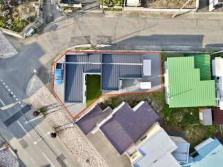 Discover this modern property featuring a sleek dark metal roof and an inviting artificial turf courtyard, perfect for relaxation or entertainment.