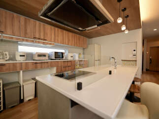 Experience modern living in this stunning kitchen featuring sleek wood cabinetry and a spacious island with a built-in cooktop.