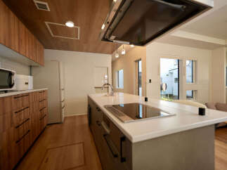 Experience modern living in this stunning kitchen featuring sleek wooden cabinetry and a spacious island with a built-in induction cooktop.