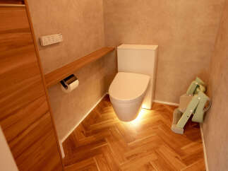 This modern bathroom features a sleek, white toilet with integrated bidet functions, illuminated by warm under-lighting for a spa-like ambiance.