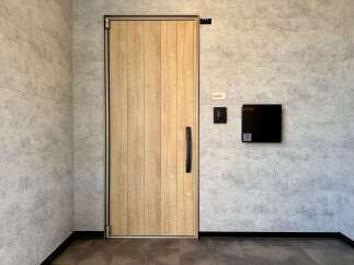 Experience modern living with this stylish entryway featuring a natural wood door and sleek black hardware.