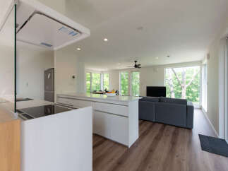 Experience modern living in this spacious open-concept home, featuring a sleek kitchen island with a built-in cooktop and a separate sink area.