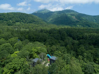 Nestled amidst lush green forests, this property offers a serene escape with modern architectural design.