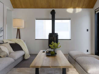 Experience modern living in this stylish living room, featuring a sleek wood-burning stove as a focal point.