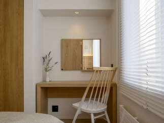 Discover a serene vanity area featuring a minimalist wooden desk and a matching chair, perfect for a morning routine.