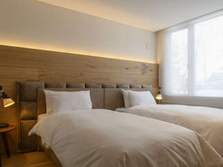 Experience modern comfort in this beautifully appointed bedroom featuring two plush twin beds, perfect for a restful night's sleep.