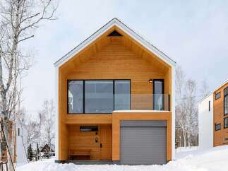Experience modern living in this stunning wooden-clad home, perfect for a snowy retreat.