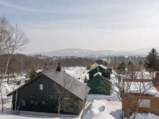 Discover this charming winter retreat featuring multiple homes nestled in a snowy landscape.