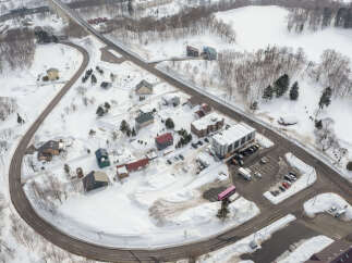 Discover this charming winter wonderland property nestled amidst snow-covered landscapes and surrounded by lush trees.