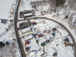 Discover this charming winter village nestled amidst snow-covered landscapes and surrounded by lush trees.