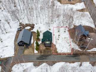 Discover this charming property nestled amidst a serene, snow-dusted landscape with mature trees.
