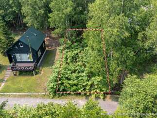 Discover this charming property featuring a cozy cabin nestled amidst lush greenery.