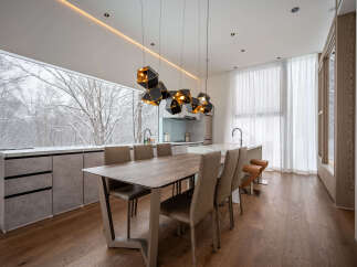 Experience modern luxury in this stunning dining area, featuring a sleek wooden table and plush chairs perfect for intimate gatherings.