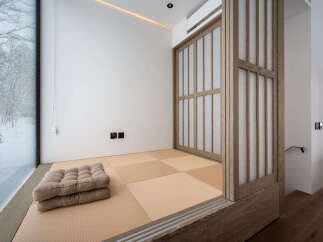 Experience serene living with this minimalist Japanese-inspired room, featuring traditional tatami flooring and a shoji screen door.