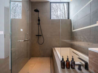 Experience ultimate relaxation in this modern bathroom featuring a deep soaking tub and a separate glass-enclosed shower.