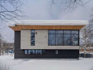 Experience modern living in this stunning home, featuring a striking combination of dark siding and light stone facade.