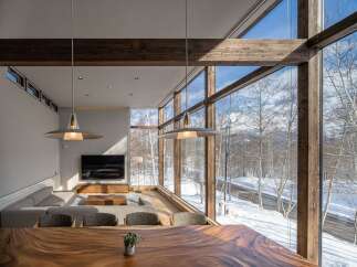Experience breathtaking mountain views from this modern living space, featuring expansive floor-to-ceiling windows that flood the room with natural light.