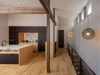 Experience modern living in this stunning home featuring a sleek kitchen with a marble island and dark wood cabinetry.