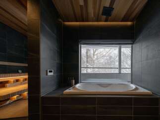Experience ultimate relaxation in this luxurious bathroom featuring a spacious soaking tub with a stunning view of the winter landscape.