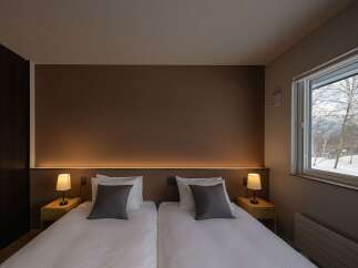 Experience comfort and tranquility in this beautifully appointed hotel room, featuring two plush twin beds perfect for a restful night's sleep.