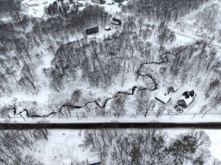 Experience the serene beauty of winter with this aerial view of a snow-covered landscape.