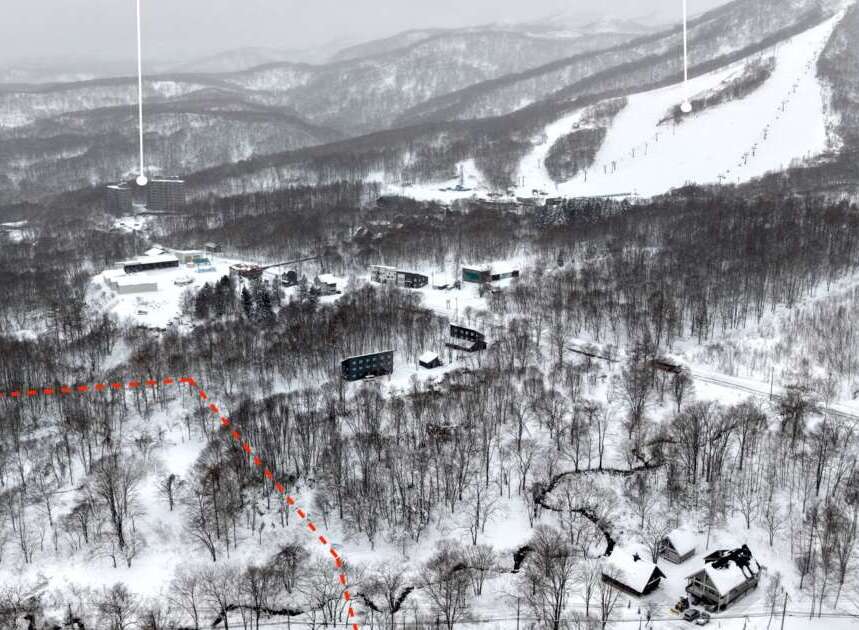Discover this expansive winter wonderland, featuring a ski resort nestled amidst snow-covered mountains and dense forests.