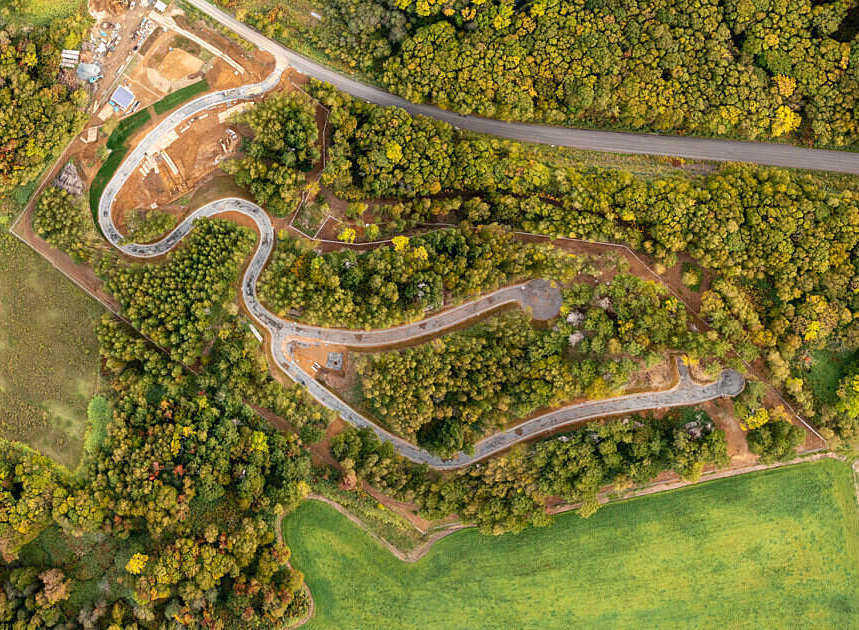 Discover this unique property featuring a winding road through lush, autumnal foliage.