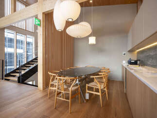 Experience modern living in this stunning property featuring an open-plan dining area with a sleek marble-top table and elegant wooden chairs.