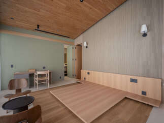 Experience modern living in this beautifully designed bedroom featuring a unique, minimalist platform bed crafted from natural wood.
