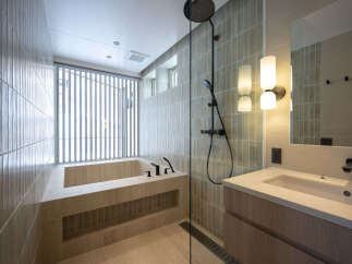 Experience modern luxury in this stunning bathroom featuring a deep soaking tub and a sleek walk-in shower with a rainfall showerhead.