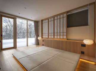 Experience serene winter views from this minimalist bedroom, featuring a low-profile tatami-style bed platform with ambient lighting.