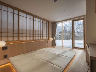 Experience serene living in this minimalist bedroom, featuring a low-profile platform bed with integrated lighting and traditional Japanese shoji screens.