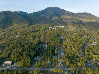Discover a serene mountain retreat nestled amidst lush green forests and rolling hills.