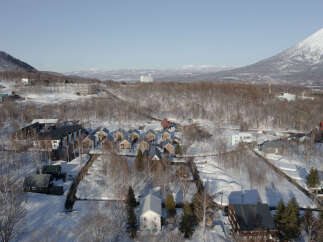 Discover this charming winter village nestled amidst snow-covered trees and majestic mountains.