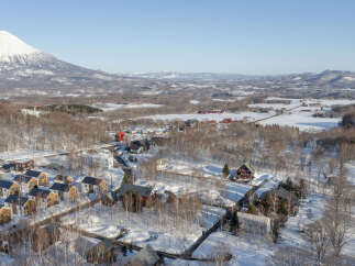 Discover this charming winter village nestled at the foot of a majestic snow-capped mountain.
