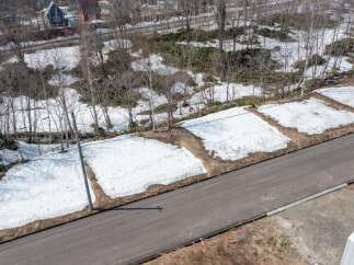 Discover this prime real estate opportunity with ample space for development, featuring a scenic view of snow-covered grounds and surrounding trees.