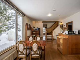 Experience cozy living with this charming dining area, featuring a warm wooden table and chairs perfect for family meals.