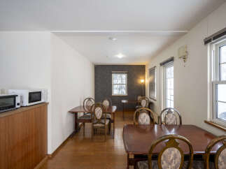 This dining area features multiple wooden tables and chairs, perfect for communal dining or small gatherings.