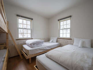 This cozy bedroom features a bunk bed and two twin beds, perfect for accommodating families or groups.