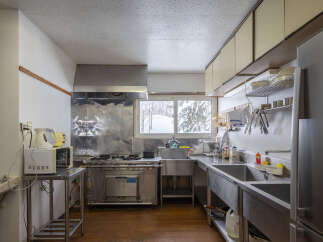 This functional kitchen features a large stainless steel range and hood, perfect for preparing meals.