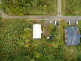 Discover this expansive property featuring a large, light-colored building with multiple roof vents, ideal for commercial or industrial use.